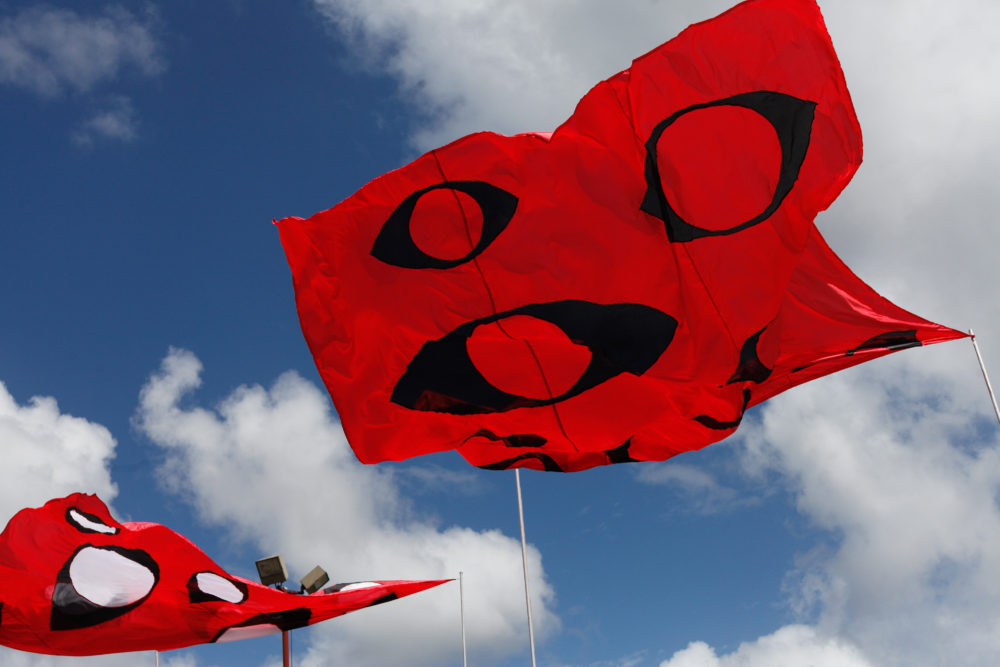 Giant flags adorned with the Eyes of God fluttering above it all
